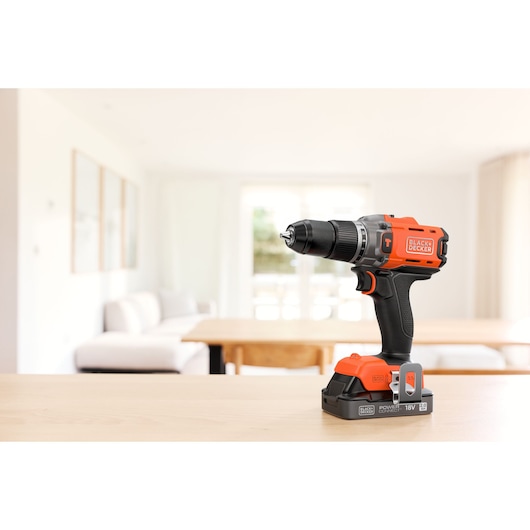 BLACK+DECKER cordless drill on a table in a bright living room.