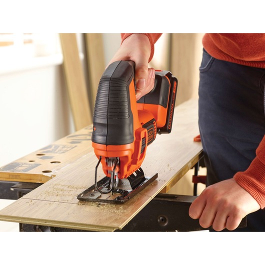 BLACKDECKER BDCJS18 cordless jigsaw cutting wood, shown in use by hand.