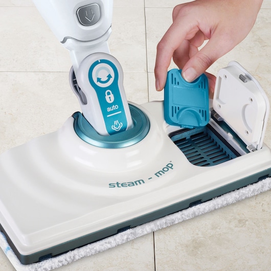 BLACKDECKER FSM3CF steam mop being loaded with a blue filter on light tile floor, close-up angle.