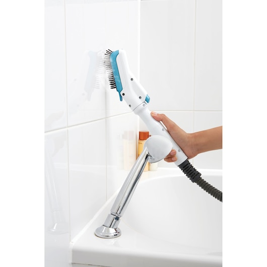 A person uses a BLACK+DECKER steam cleaning brush to clean white tiled bathroom walls above a bathtub.